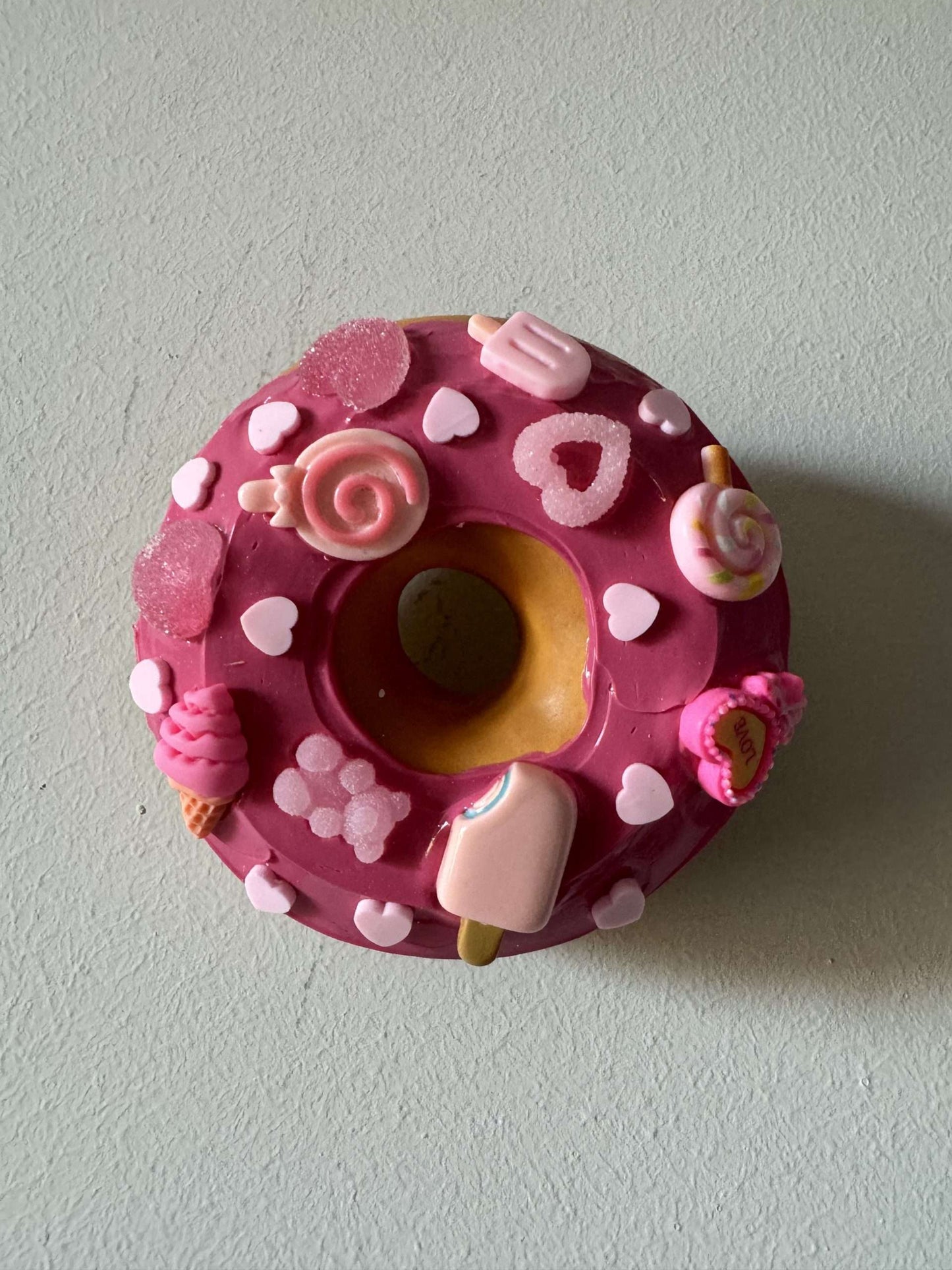 Donut with fuchsia icing and colored candies