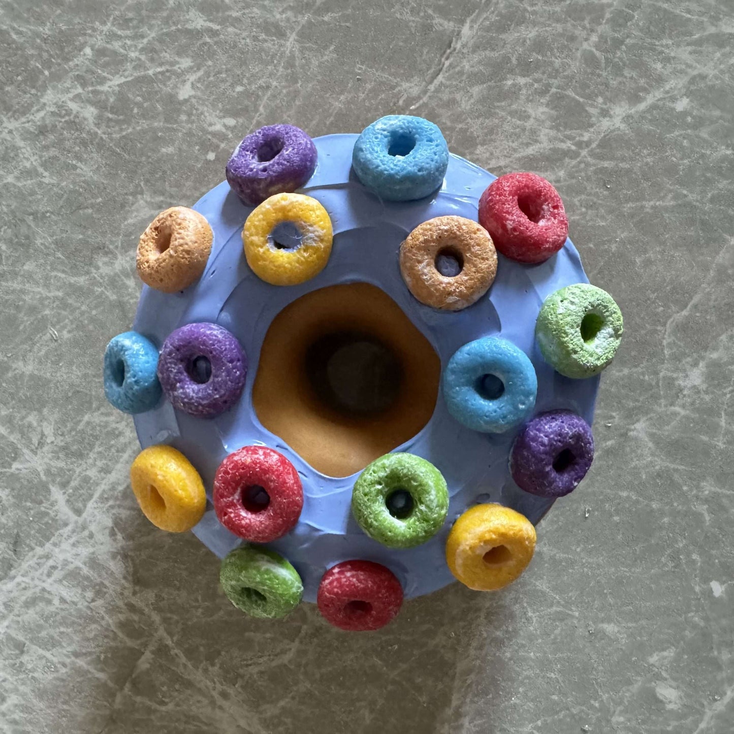 Donut with light blue icing and round colored cereals